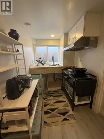 Vancouver apartment for rent - A small kitchen with a black stove top oven.