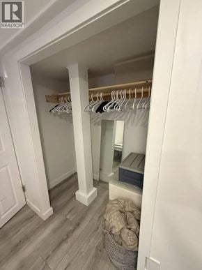Vancouver apartment for rent - A white closet with a mirror and a basket of clothes.