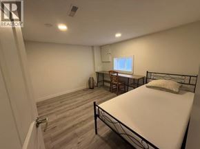 Vancouver apartment for rent - A bedroom with a bed, chair, and window.