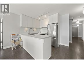 New Westminster apartment for rent - A white kitchen with a refrigerator, sink, and cabinets.
