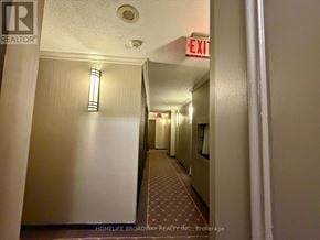 Toronto (Annex) condo for rent - A long hallway with a red exit sign at the end.