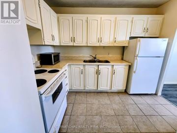 St. Catharines (Glendale/Glenridge) condo for rent - A kitchen with white cabinets and appliances.