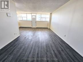 St. Catharines (Glendale/Glenridge) condo for rent - A room with wooden flooring and white walls.