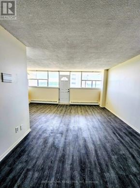 St. Catharines (Glendale/Glenridge) condo for rent - A room with a wooden floor and a white door.