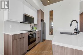 Hamilton (Corktown) condo for rent - A modern kitchen with a white countertop and wooden cabinets.