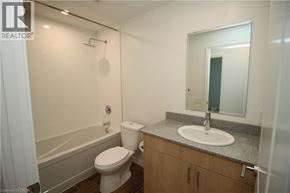 Guelph condo for rent - A bathroom with a toilet, sink, and bathtub.