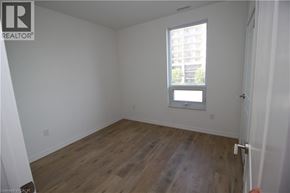 Guelph condo for rent - A room with wooden floors and a window.