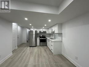 Clarington (Bowmanville) apartment for rent - A modern kitchen with white cabinets and stainless steel appliances.