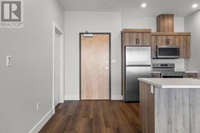 Charlottetown condo for rent - A kitchen with a wooden door and a refrigerator.