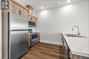Charlottetown condo for rent - A modern kitchen with a stainless steel refrigerator and wooden cabinets.