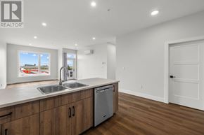 Charlottetown condo for rent - A modern kitchen with wooden cabinets and a stainless steel sink.