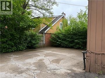 Hamilton apartment for rent - A cracked driveway leads to a house with a gate.