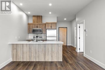Charlottetown condo for rent - A modern kitchen with wooden cabinets and a white island.