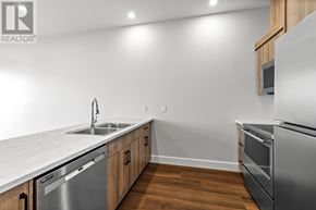 Charlottetown condo for rent - A modern kitchen with stainless steel appliances and wooden cabinets.