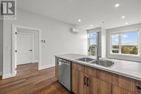 Charlottetown condo for rent - A modern kitchen with wooden cabinets and a stainless steel dishwasher.