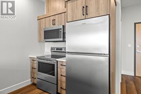Charlottetown condo for rent - A kitchen with a refrigerator, oven, and microwave.