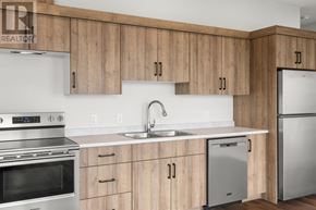 Charlottetown condo for rent - A kitchen with wooden cabinets and stainless steel appliances.