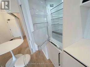 Toronto (Dovercourt-Wallace Emerson-Junction) condo for rent - A white fridge in a kitchen with a white table and white chairs.