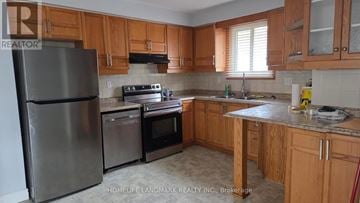 Hamilton (Fessenden) apartment for rent - A kitchen with wooden cabinets and a stainless steel refrigerator.
