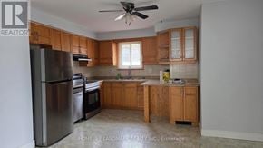 Hamilton (Fessenden) apartment for rent - A kitchen with wooden cabinets and a stainless steel refrigerator.
