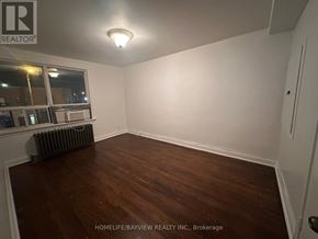 Toronto (Keelesdale-Eglinton West) apartment for rent - A room with wooden flooring and white walls.