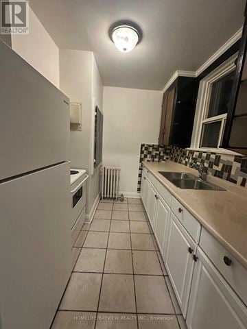 Toronto (Keelesdale-Eglinton West) apartment for rent - A kitchen with white cabinets and a black and white tiled backsplash.