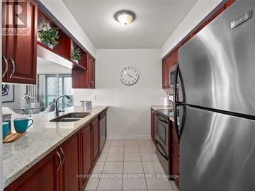 Toronto (Bendale) condo for rent - A kitchen with a stainless steel refrigerator and wooden cabinets.
