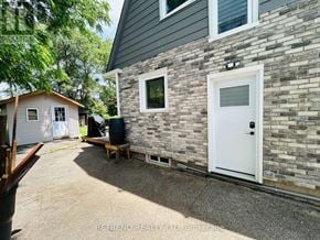Toronto (Lansing-Westgate) apartment for rent - A house with a white door and windows is surrounded by a gravel driveway.
