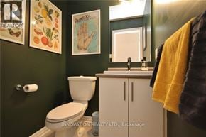 Ottawa townhouse for rent - A bathroom with a toilet, sink, and a mirror.
