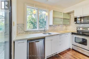 Toronto (Wychwood) apartment for rent - A modern kitchen with white cabinets and stainless steel appliances.