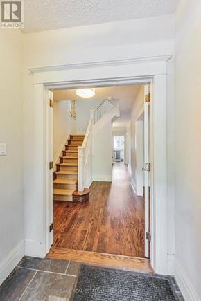 Toronto (Wychwood) apartment for rent - A hallway with a staircase and a rug on the floor.