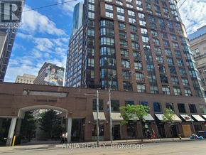 Toronto (Church-Yonge Corridor) condo for rent - A street view of Carlton Street with a building in the foreground and a clear blue sky above.