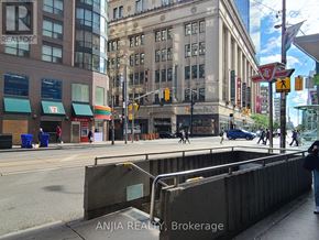 Toronto (Church-Yonge Corridor) condo for rent - A city street with a pedestrian crossing and a person walking across the street.