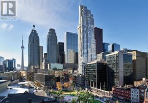 Toronto (North St. James Town) condo for rent - A cityscape with a mix of modern and older buildings, with a clear blue sky above.