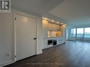 Toronto (North St. James Town) condo for rent - A spacious kitchen with white cabinets and a large window.