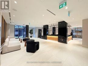 Oshawa (Windfields) condo for rent - A spacious lobby with a reception desk and seating area.
