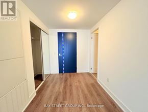 Oshawa (Windfields) condo for rent - A long hallway with a blue door at the end.