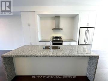 Vaughan (Vellore Village) townhouse for rent - A kitchen island with a granite countertop and a stove top oven.