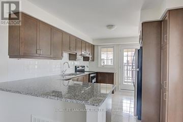 Richmond Hill townhouse for rent - A kitchen with brown cabinets and a granite countertop.