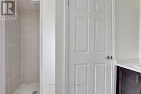 Richmond Hill townhouse for rent - A white door in a bathroom with a tiled shower area.