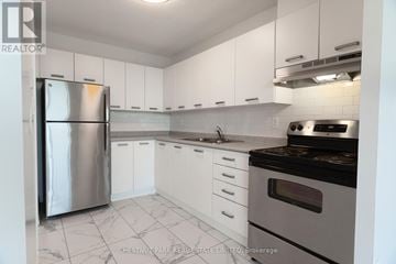 Mississauga (Port Credit) multi-family for rent - A kitchen with white cabinets and a stainless steel refrigerator.