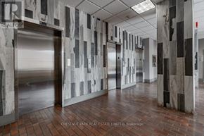 Mississauga (Port Credit) multi-family for rent - A hallway with a marble patterned wall and a metal door.