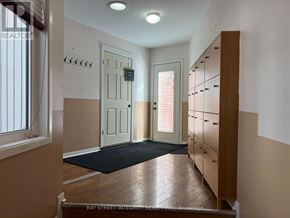Oakville (Wo West) apartment for rent - A hallway with a black mat on the floor and a wooden cabinet on the right.