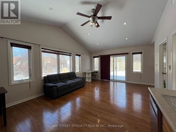 Oakville (Wo West) apartment for rent - A spacious living room with a grey sofa and wooden flooring.
