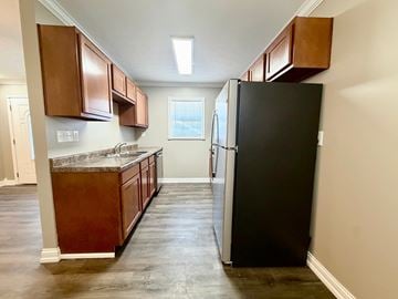 Louisville apartment for rent - A kitchen with a black refrigerator and brown cabinets.