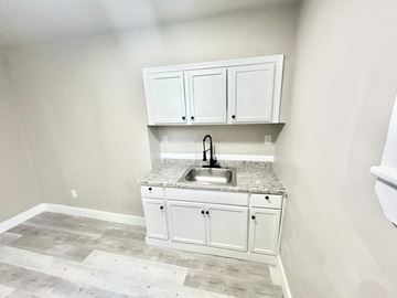 Gary apartment for rent - A kitchen with a granite countertop and white cabinets.