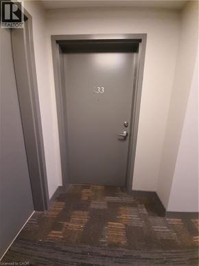 Waterloo condo for rent - A door with the number 33 on it is in a hallway.