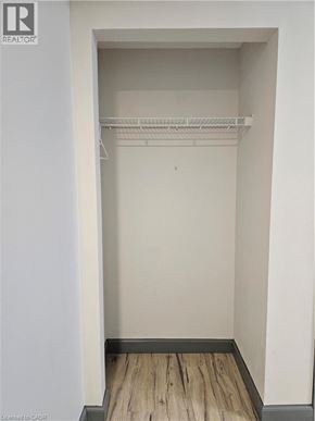 Waterloo condo for rent - A small, empty closet with a wooden floor.