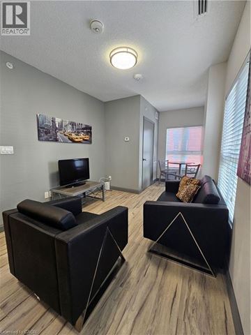 Waterloo condo for rent - A living room with a black couch and a television.
