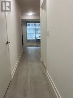 Toronto (Waterfront Communities) condo for rent - A hallway with a door on the left and a window on the right.